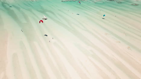 drone shot of kitesurfers gliding over shallow waters
