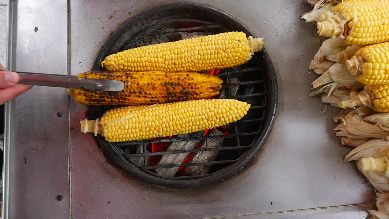 Street Vendor Grilling Fresh Corn on Charcoal Grill