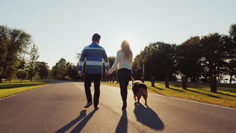 Pareja-Paseando-A-Un-Perro-En-Un-Parque