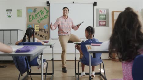 Profesor-Birracial-Enseñando-A-Estudiantes-Diversos-En-El-Aula-De-La-Escuela-Primaria