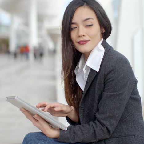 Stylish-woman-surfing-the-internet-in-town