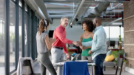 team of diverse colleagues shaking hands with each other at office