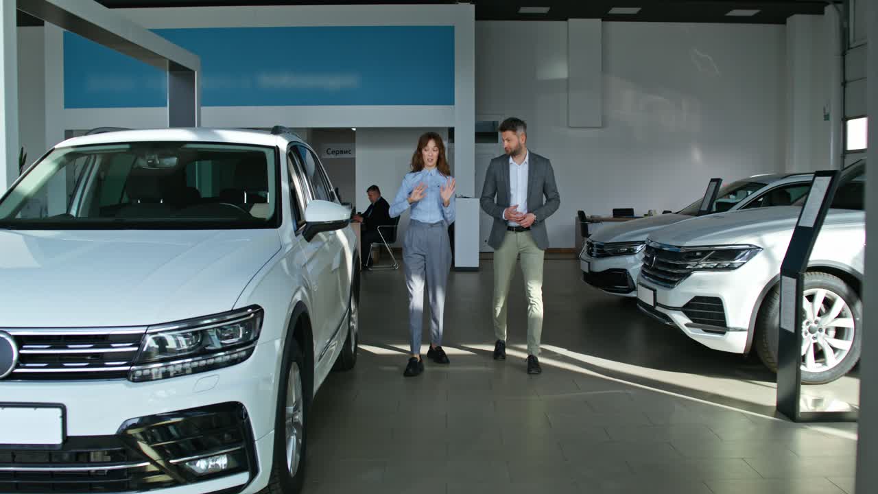 vendedor de automóviles mostrando el suv al cliente en la sala de exposiciones
