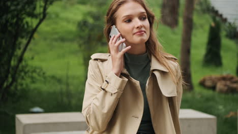 caucasian female student talking on the phone outdoors.