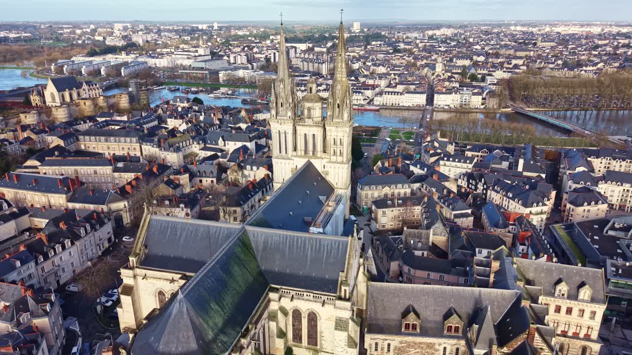 Saint-Maurice Cathedral with the historic Château d'Angers and the Maine river in the background in Angers, France. Aerial drone backward, cityscape