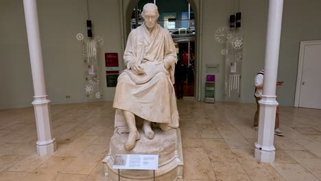 visitors observe a statue in the museum