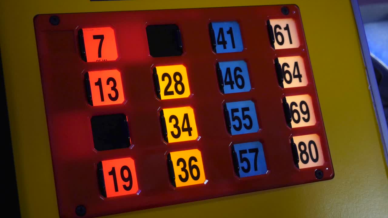 Close up of a bingo machine card lit up in an amusement with a young girl playing the game