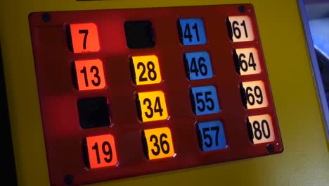 close up of a bingo machine card lit up in an amusement with a young girl playing the game