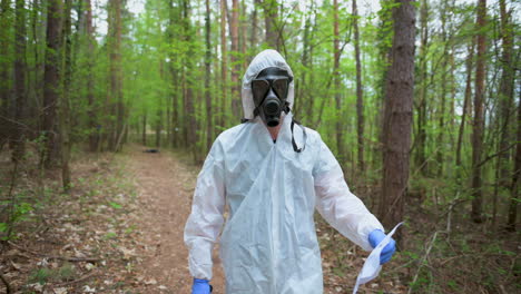 tracking shot of a man with an overall and a mask walking in a forest, 4k