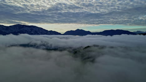 clouds gather beneath the mountain peaks