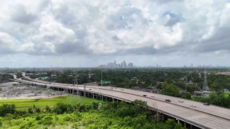 A-distant-approaching-aerial-view-a-downtown-skyline,-on-a-cloudy-day