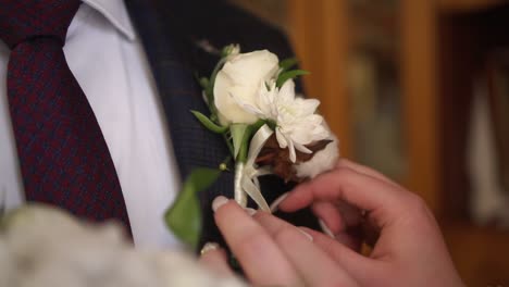 the bride wears a boutonniere to the groom