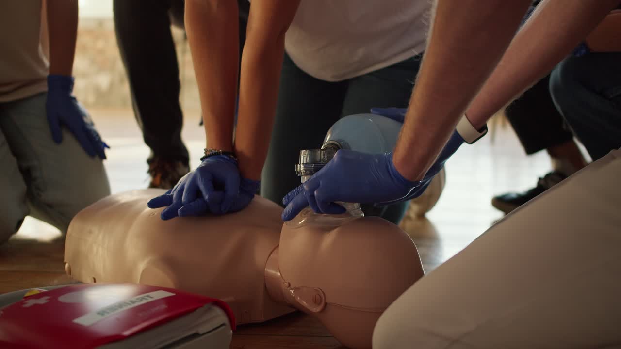 disparo de primer plano: dos personas realizan la rcp con la ayuda de un maniquí y una bolsa de reanimación de ambulancia. formación práctica. formación en primeros auxilios