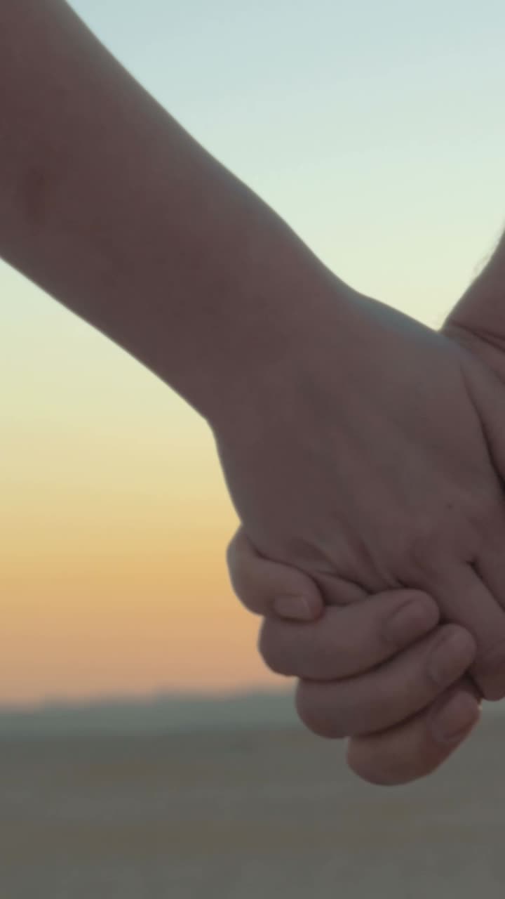 해가 지면 손을 잡고 있는 커플