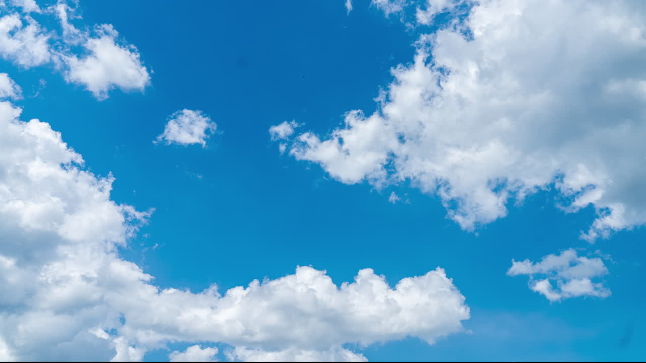 Bright blue skies with white clouds passing by. Soft clouds transformation in the atmosphere. Timelapse.
