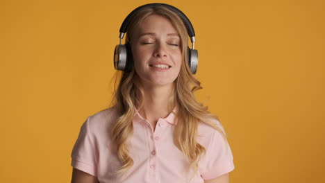 una mujer caucásica con auriculares escuchando música.