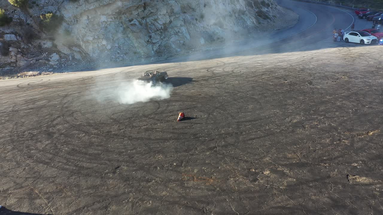 Done shot of a Mazda Miata with muscle and sports cars doing doughnuts and burnouts with a car club in the Angeles National Forest in Southern California