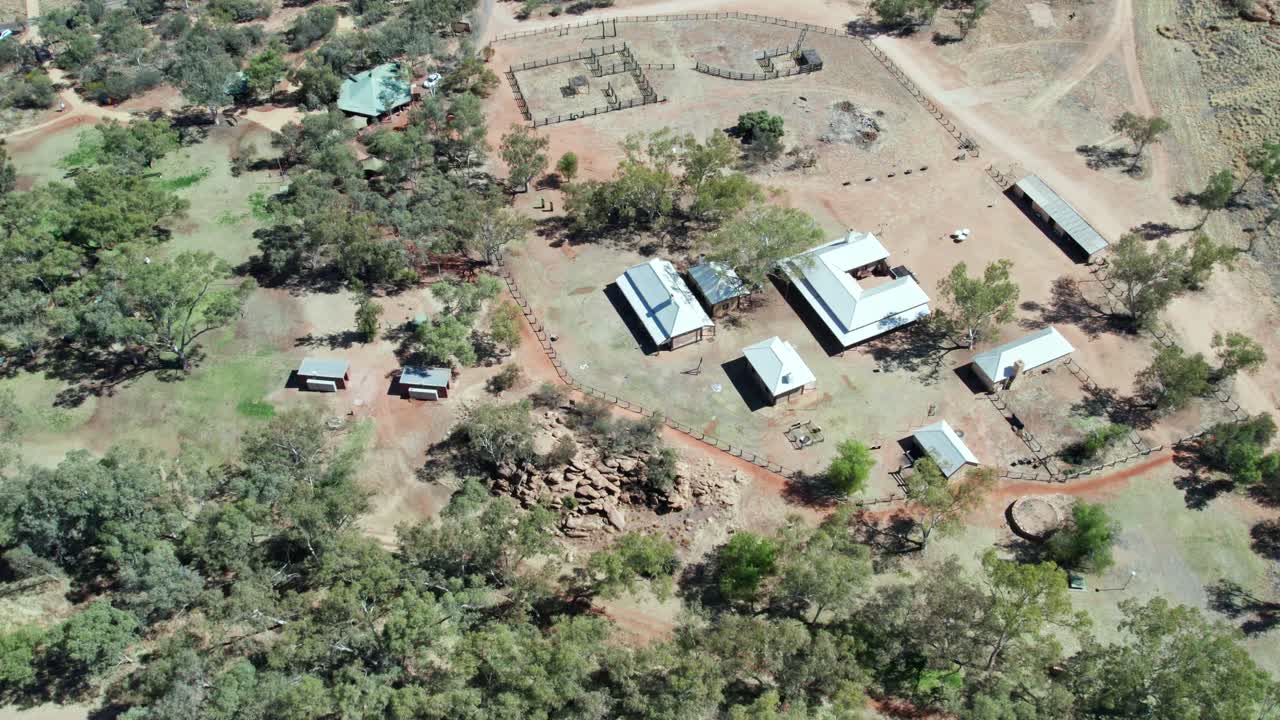 Sideways aerial view along the Alice Springs Telegraph Station Historical Reserve, north of Alice Springs, Mparntwe, Northern Territory, Australia. August 2022.