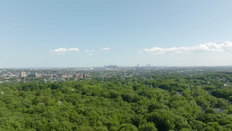 aerial flying above woods, tracking boston skyline in distance