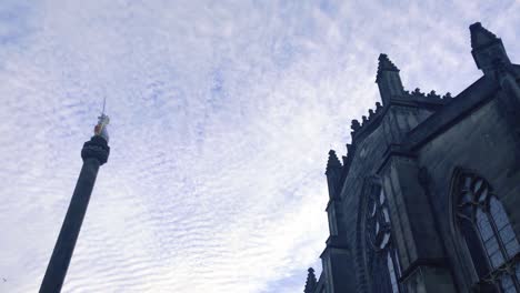 slow moving clouds moving above a church and statue, on a cold and cloudy day in scotland