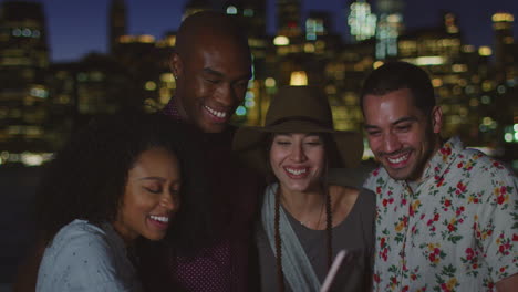 Group-Of-Friends-Posing-For-Photo-In-Front-Of-Manhattan-Skyline-At-Dusk