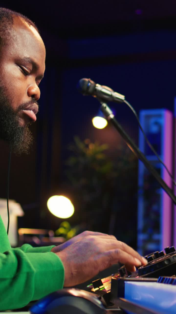 African American Man Wearing Headphones Mixing Music in Studio
