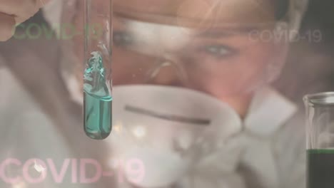 trabajador de la salud mirando un tubo de ensayo durante la pandemia de coronavirus covid19