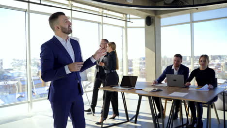 people work in office. elegant businessman in suit talking on camera. men and women entrepreneurs working in groups in modern office center in the city.