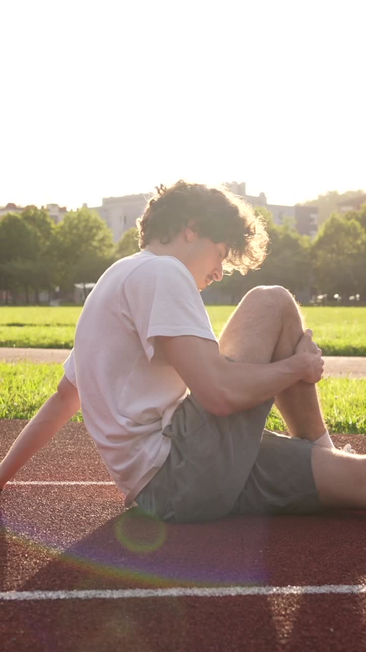 Man Stretching on Running Track