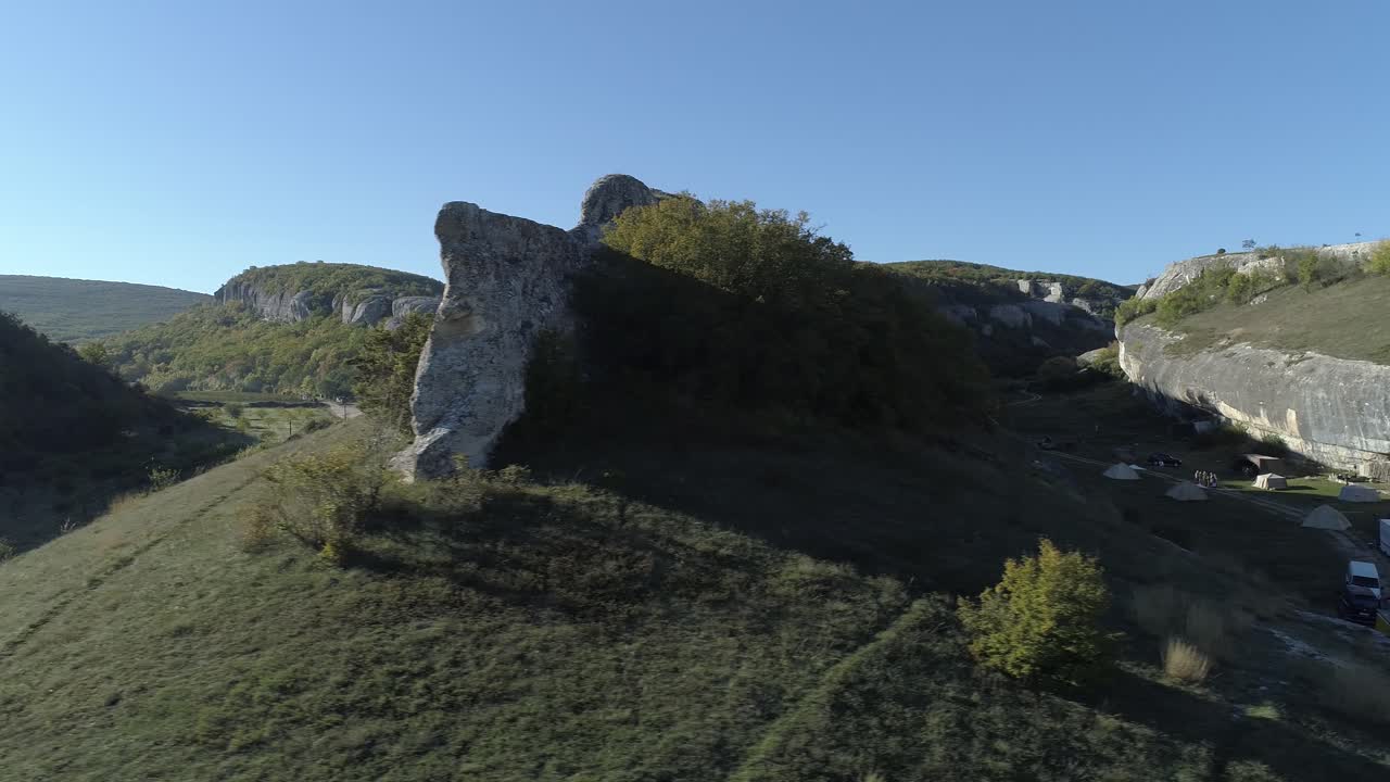 Flygfoto över en historisk plats med klippformationer och campingområde