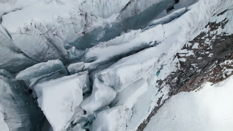 Vista-Aérea-De-Cerca-De-Las-Grietas-En-El-Borde-De-Un-Gran-Glaciar-En-Un-Día-Soleado-En-Invierno-En-Los-Alpes