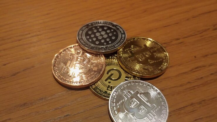 Denaro digitale, criptovalute come i token Blockchain e Web 3, Bitcoin e Polkadot che riflettono un bagliore di luce su una superficie di legno, ripresa ravvicinata dall'alto, Galizia, Spagna