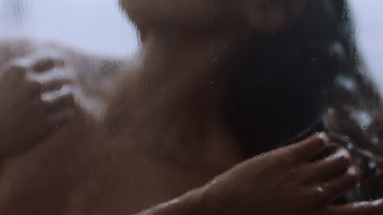 mujer hermosa tomando una ducha tocando la piel húmeda disfrutando de un spa de lujo limpiando el cutis suave