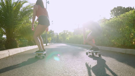 En-Medio-De-La-Tranquilidad-De-La-Isla,-Andan-En-Patineta-Por-Los-Senderos-Del-Parque-En-Cámara-Lenta,-El-Brillo-Del-Atardecer-Se-Suma-A-Su-Alegría-Y-Estilo-De-Vida-Saludable.