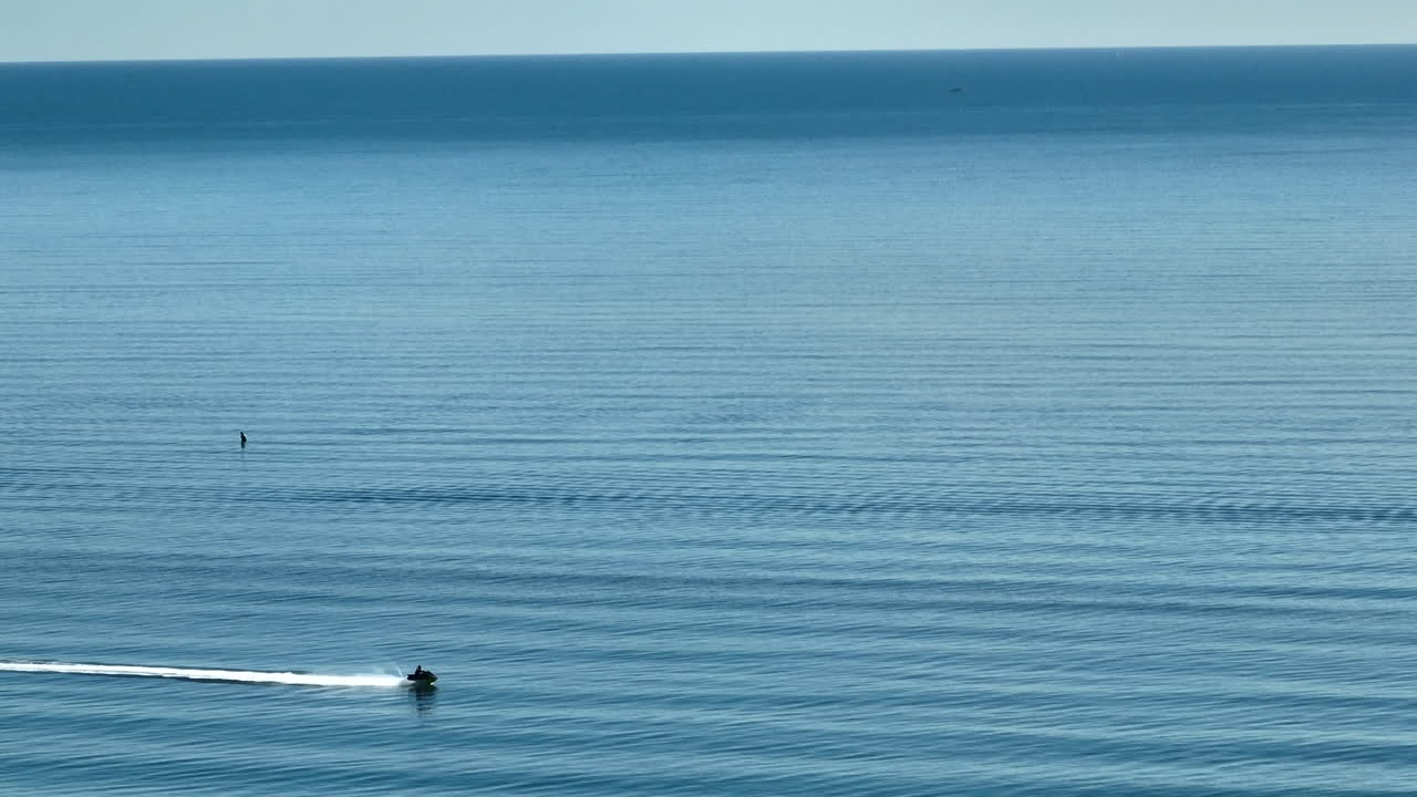 뉴질랜드 태즈만 만에서 물 위를 빠르게 이동하는 제트 스키 라이더의 드론
