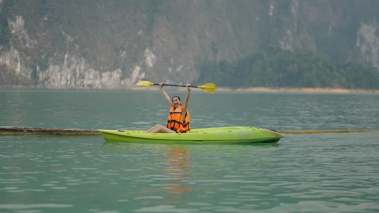 Woman Kayaking on a Scenic Mountain Lake