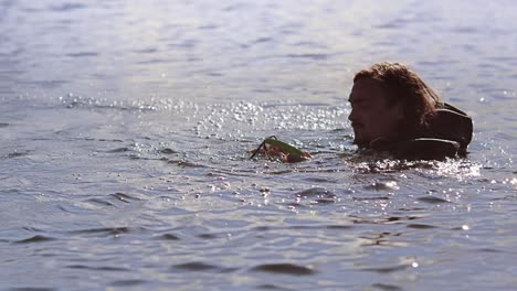 man in waterproof clothing preparing ride wake board. fail in water sports