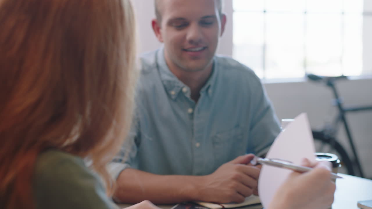 jóvenes empresarios diversos firmando contratos mujeres empresarias escribiendo firmas en documentos legales disfrutando de una reunión de asociación corporativa en una oficina moderna