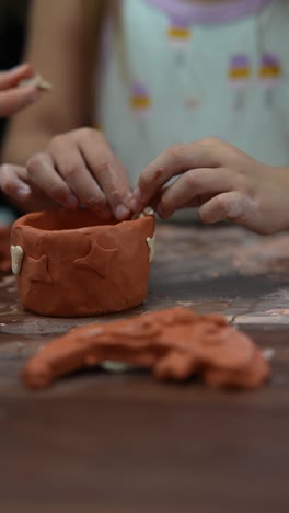 child making a clay bowl