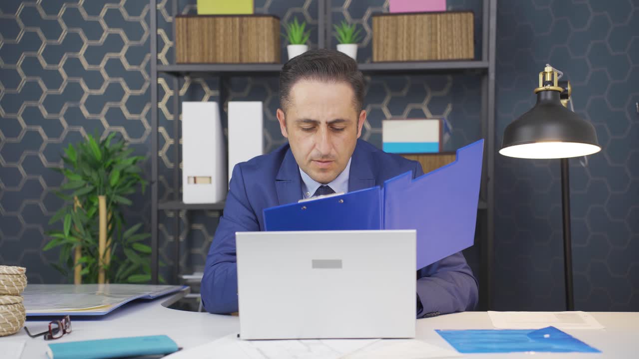 서류 파일을 보고 있는 사업가입니다.