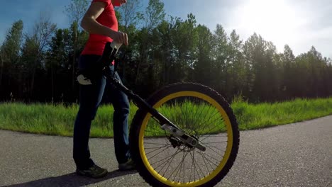 Woman-passing-through-the-road-with-unicycle-4k