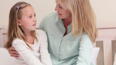 Mother-and-daughter-talking-on-bed