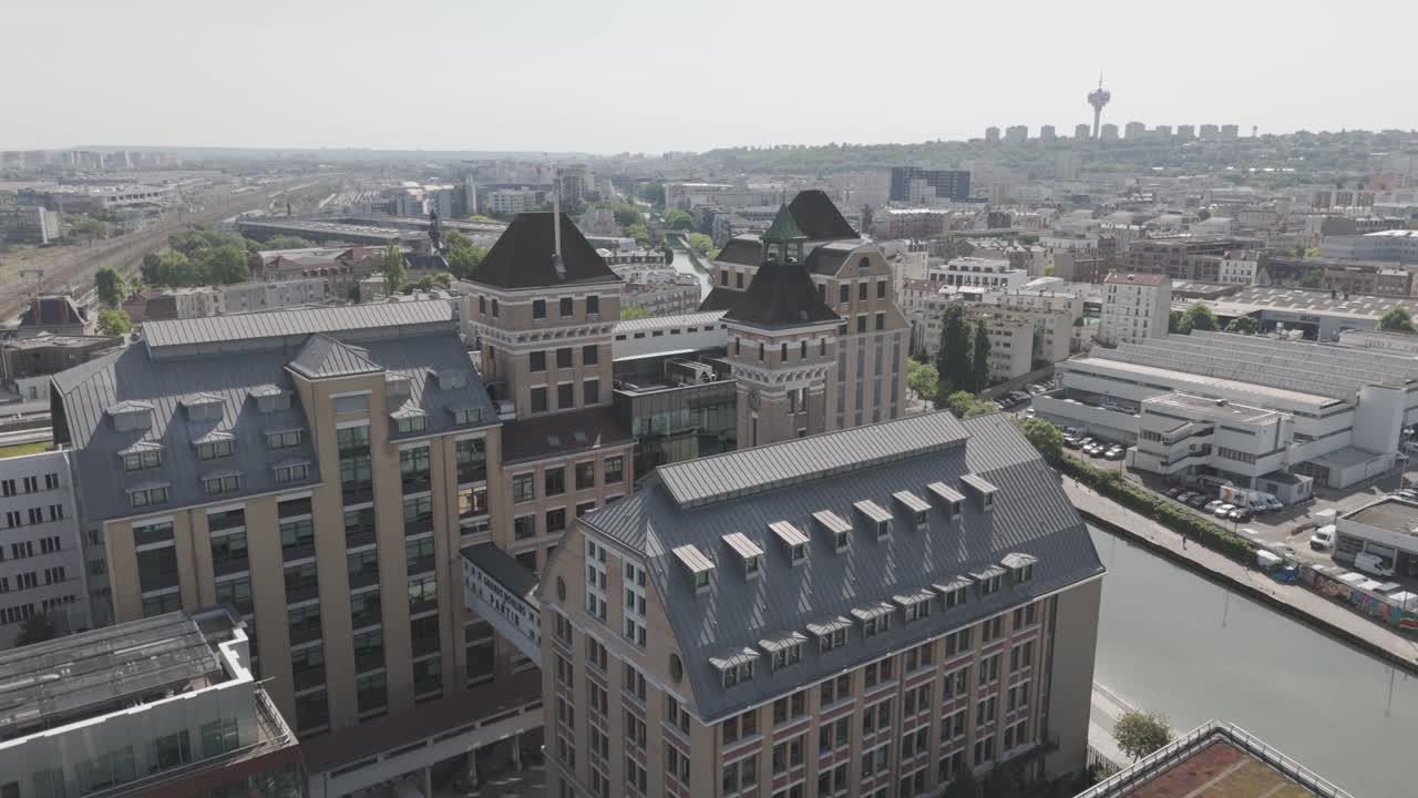 Aerial drone view of the Grands Moulins de Pantin building and the Canal de l'Ourcq, with the Pantin district in the background - France