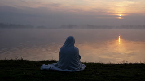 serene dawn over a misty lake with a contemplative figure