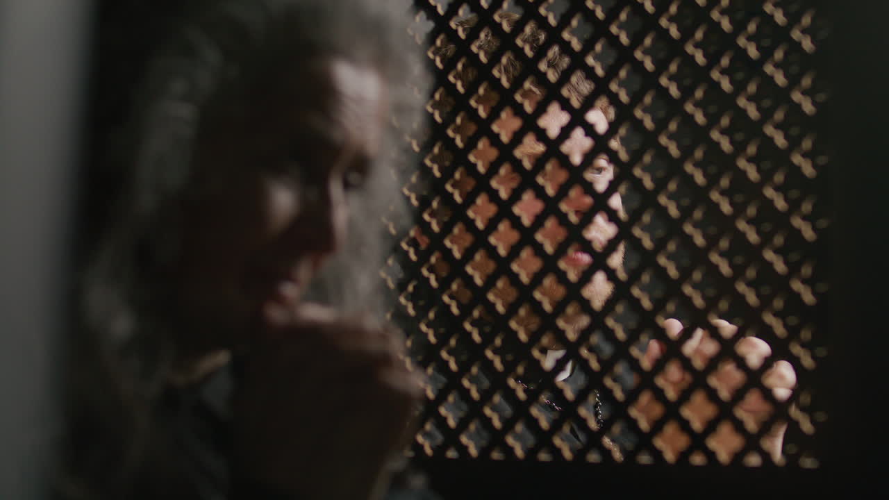 Priest Speaking behind Lattice Screen during Confession of Senior Woman