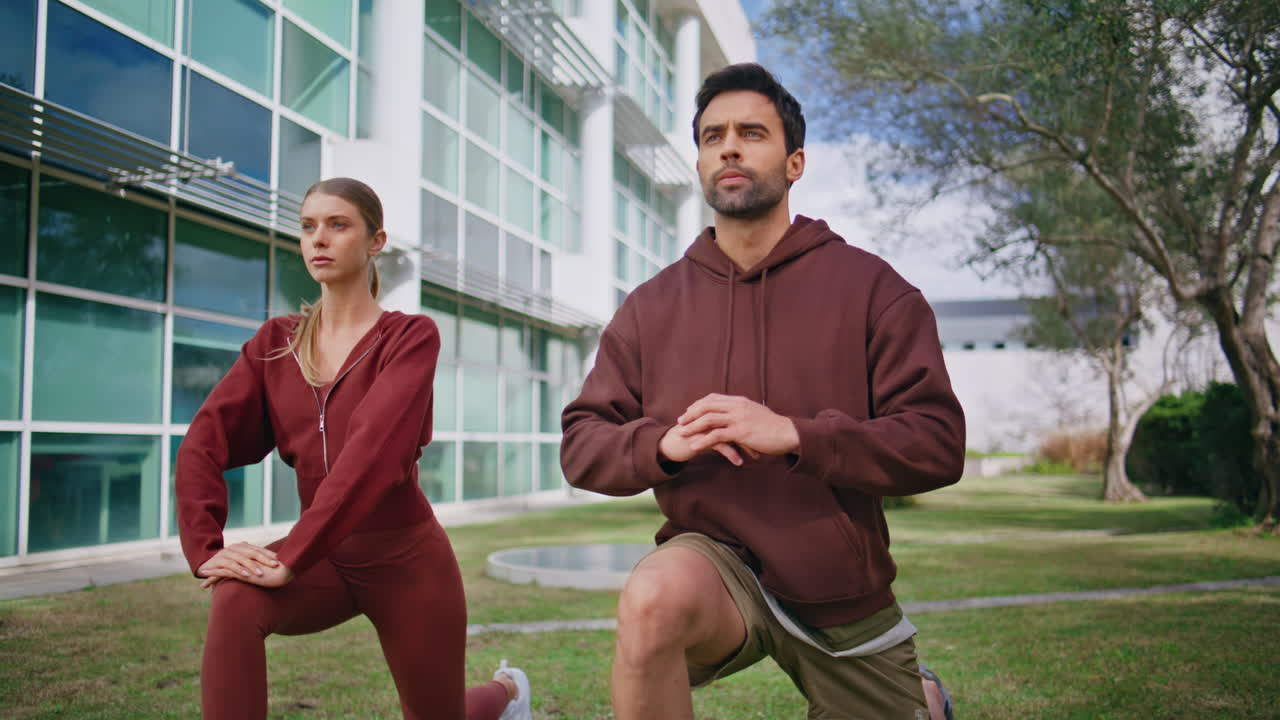 Sport friends performing lunges in morning. Man coach instructing fit woman