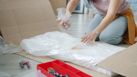 Woman Unpacking and Assembling Furniture
