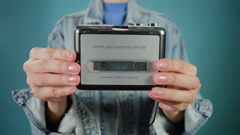 persona que sostiene un dispositivo de captura de cassette usb retro
