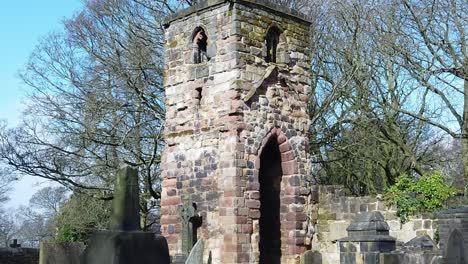 historic windleshaw chantry stonework tower exterior slow motion around cemetery ruins against blue sky