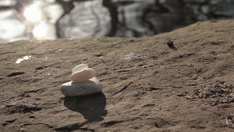 Zen-stones-at-waterfront-with-sun-rays